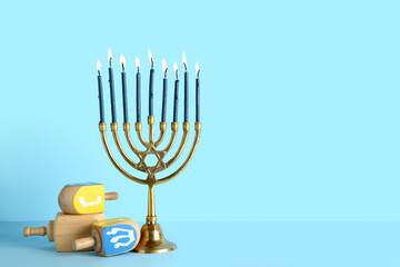 Menorah with dreidels on blue background. Hanukkah celebration - obrazy, fototapety, plakaty