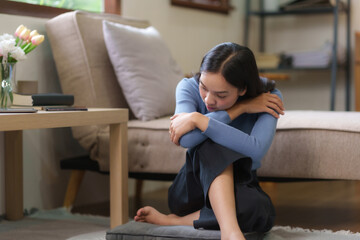 Young Asian woman suffering from stress sit alone at home, dejected. Desperate Asian woman feeling lonely