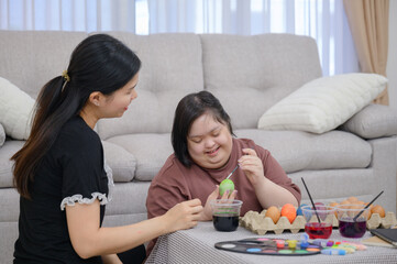 Asian family of disabled older sister and sister with Down syndrome A young woman with Down...