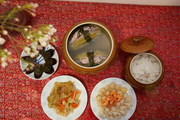 Family dinning table of Tet holiday or Lunar New Year with traditional foods: pork belly and eggs...