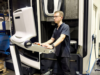 A worker familiarizes himself with the new equipment of a CNC milling machine