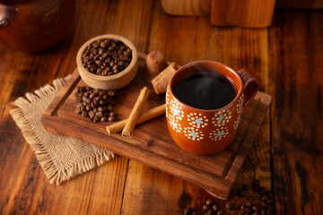 Cafe de Olla, Mexican-style coffee prepared with roasted and ground coffee beans, cinnamon and piloncillo. Traditional recipe prepared in a clay pot and served in a clay cup called a jarrito.