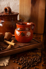 Cafe de Olla, Mexican-style coffee prepared with roasted and ground coffee beans, cinnamon and piloncillo. Traditional recipe prepared in a clay pot and served in a clay cup called a jarrito.