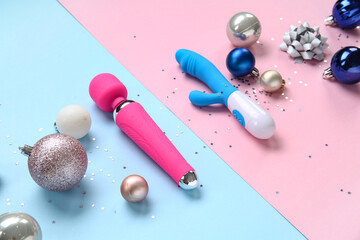 Composition with vibrators and Christmas decorations on color background