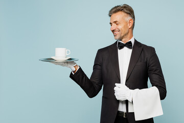 Adult barista male waiter butler man wears shirt black suit bow tie elegant uniform hold towel metal tray with cup of coffee work at cafe isolated on plain blue background Restaurant employee concept - Powered by Adobe