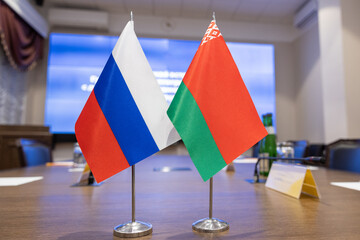 Flags of cooperation between Russia and Belarus. Flags of Russia and Belarus on the negotiating table. Ideal for news. - obrazy, fototapety, plakaty