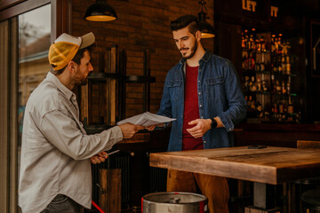 A shot captures the restaurant worker inspecting the quality of the received drinks, ensuring that all items meet the established standards before being accepted into the inventory.