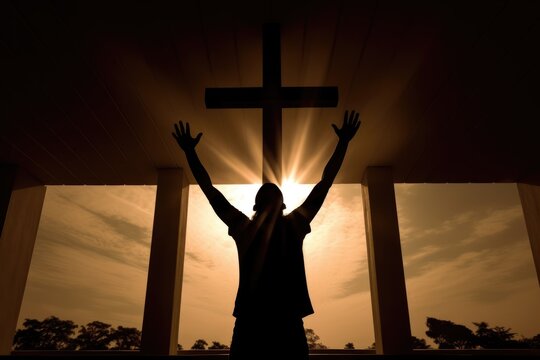 Man raised his hands and praises God, looks at the cross. Man believes in God. Hope in God. Salvation, worship concept