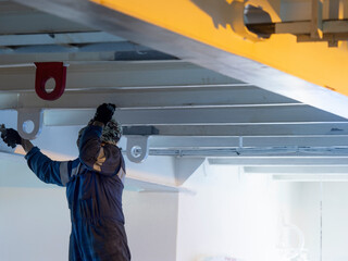 Seaman ship crew working on deck painting the at aft manouvering station