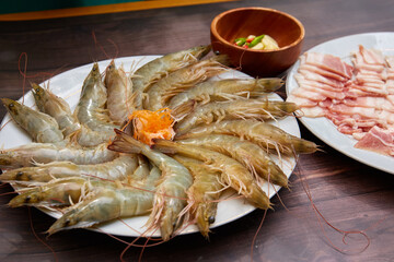 BBQ set. Dishes full of raw shrimps and pork ready to grill