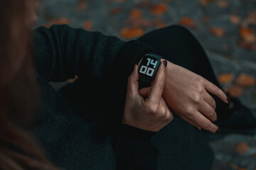 A woman looking at her smartwatch on hand. 