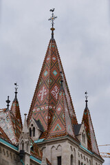 Fototapeta na wymiar Spire with cross on the roof top of a Fisherman's Bastion (Hungarian: Halászbástya). Budapest, Hungary - 7 May, 2019