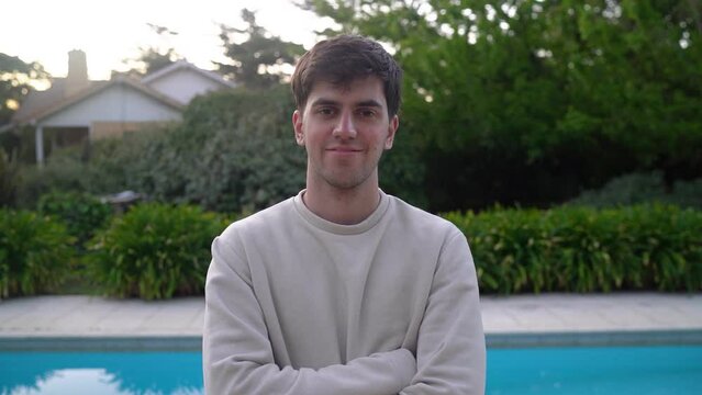 Portrait Of A Smiling Young Man Standing Near Swimming Pool. Zoom In