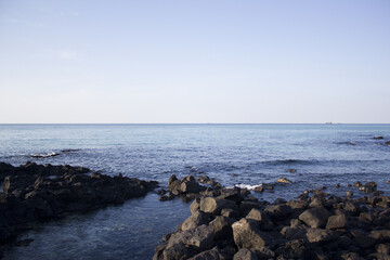 
It is a beach with black basalt rocks.