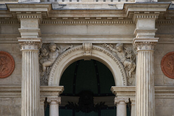 Arch of Varkert Bazar (Hungarian: V&aacute;rkert Bazaar or V&aacute;rbaz&aacute;r) decorated with columns and angels sculptures. Budapest, Hungary - 7 May, 2019