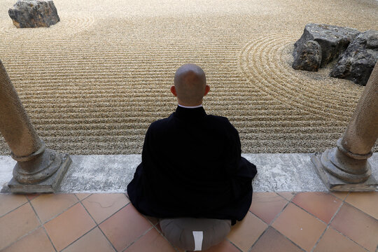Zen buddhist monk practising zazen (meditation) in Orval trappist abbey's zen garden, Belgium.