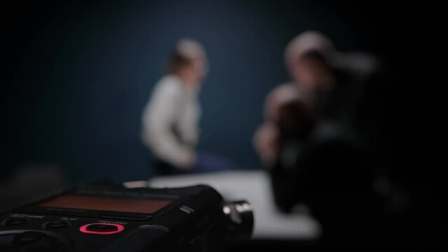 Close up digital voice audio recorder, blinking REC button. Police interrogation without lawyer. Detective cop shows evidence bag. FBI agent threatens mafia. Officers are trying to extract confession