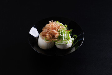 Japanese tofu Japanese appetizer soft cold tofu with sauce ginger and green onion topping isolated in black background