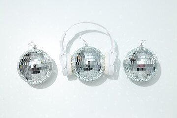 A beautiful disco ball with headphones on a light background