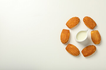 Madeleine cakes and cream on white background, space for text