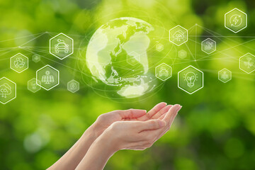 Environmental technology and Sustainable development goal (SDGs) concept. Hands holding Global communication network with Environment icon on a green background.