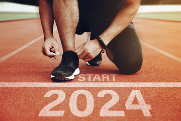 Athletes are getting ready to run on the track with the text  2024 in New Year's Start concept. start the new year 2024 and reach new goals and achievements. planning, challenges, new year resolution. - obrazy, fototapety, plakaty