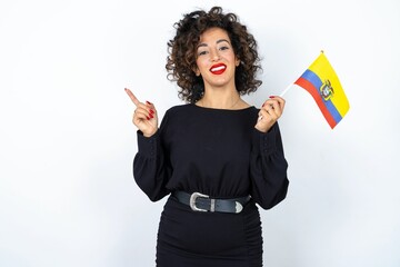 Young beautiful woman with curly hair wearing black dress and holding and Ecuador flag.