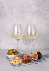 Food photography of white wine; cheese; parmesan; fig; prosciutto; pecan; olive; slice; wineglass; chardonnay; sauvignon; winery; background, celebration