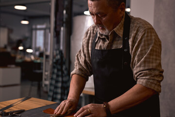 tailor uses old piece of cloth and gives the grain side of the leather a couple coats of oil. close...