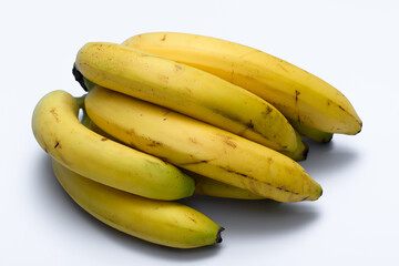 Kilka sztuk dojrzałych bananowa leży na jasnym tle