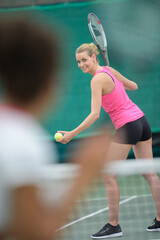 portrait of tennis player serving ball