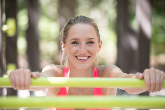 woman standing by monkey bar exercise equipment outdoors