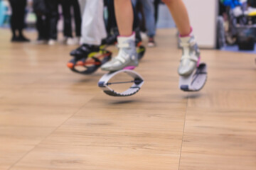 Kangoo shoes, fitness jumping training, group of young fit women in sportswear on kangoo jumps,...