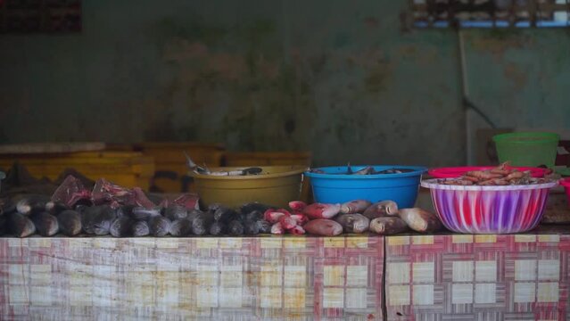 The fish are arranged in a row on the table for sale. Indonesian fish market - Skipjack tuna and red snapper
