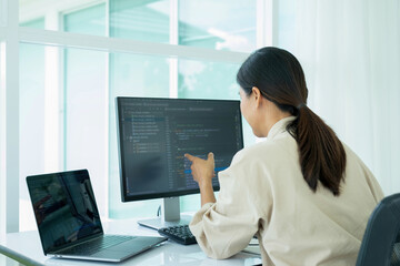 Female IT programmer innovates at office desk.