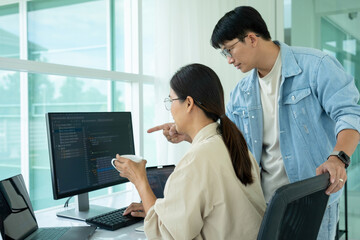 IT programmers working together at office desk.