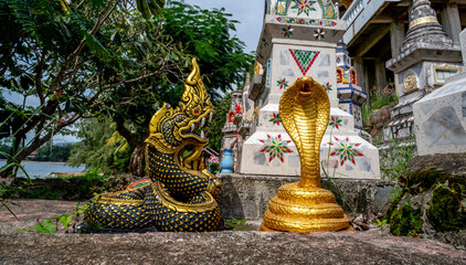 Fototapeta premium Snake sculptures in a Buddhist cemetery at the Wat Sila Ngu temple in Thailand