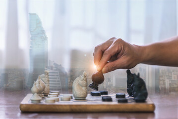 Businessman's hand moving a chess piece in a competitive success play. idea of leadership, management, or strategy