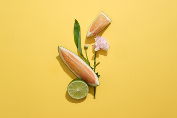 Pomelo, lemon and flowers are placed on a yellow background. Pomelo and lemon are two succulent...