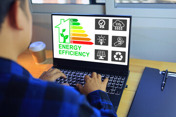 Man working with home energy rating label on laptop computer screen to select most highest...