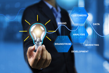 Businessman hand holding light bulb with marketing network icon and analysis solution development...