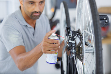man adding oil on wheel bike - obrazy, fototapety, plakaty