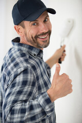 cheerful painter decorator giving thumbs up © auremar