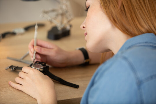 young woman repairing a wristwatch