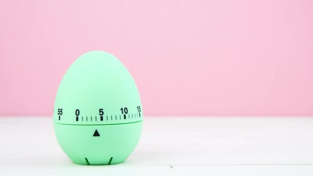 4K blue kitchen egg timer on a pink background. cooking time, soon Easter. horizontal, copy space