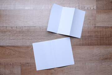Composition of white blank flyer trifold paper and bifold paper on wooden background