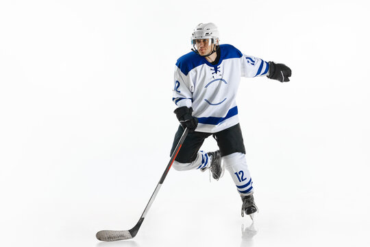 Dynamic image of young man, hockey player in motion on rink, training, playing against white studio background