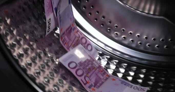euro 500 paper money banknotes in the washing machine. dirty criminal money laundering and shadow economy concept