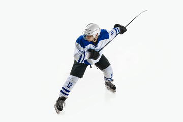 Man, ice hockey player in motion during game with stick, training, playing against white studio background