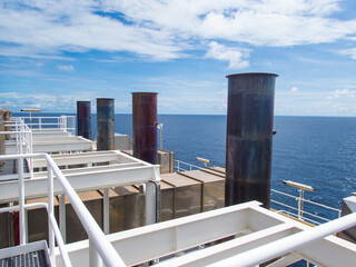 Obraz premium Smoke stacks from offshore gas and oil drilling rigs in the petroleum industry.